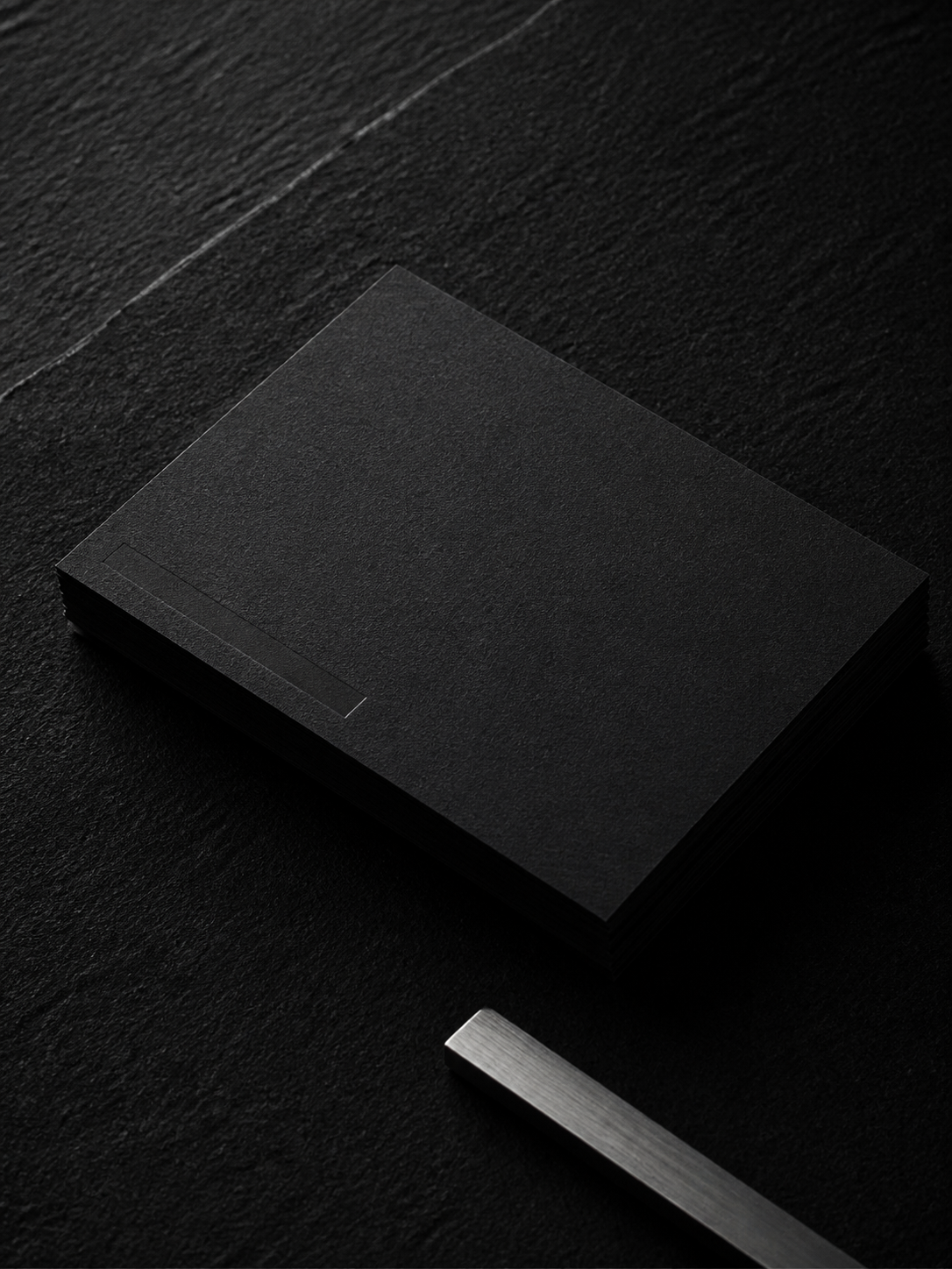 Blank black business cards on black textured paper